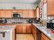 Modern kitchen with granite counters, stainless appliances, and decorative backsplash at 8811 Pauley Hills St, Las Vegas, NV 89131