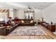 Comfortable living room with leather sofas, decorative window treatments, and a plush rug at 8811 Pauley Hills St, Las Vegas, NV 89131