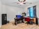 Home office with a desk, wood-look floors, ceiling fan, and natural light at 8811 Pauley Hills St, Las Vegas, NV 89131