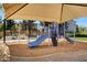 Playground with slides and climbing structure shaded by a canopy, with mature landscaping and seating at 8811 Pauley Hills St, Las Vegas, NV 89131