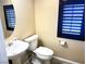 Powder room with pedestal sink and blue-trimmed window at 9535 Leaping Lizard St, Las Vegas, NV 89178