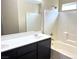 Bathroom features a double sink vanity and a shower over tub at 9535 Leaping Lizard St, Las Vegas, NV 89178