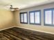 Bedroom with stylish hardwood floors, ceiling fan, and shuttered windows at 9535 Leaping Lizard St, Las Vegas, NV 89178