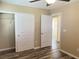 Bedroom featuring a ceiling fan, wood-look floors, closets, and an open door to the hallway at 9535 Leaping Lizard St, Las Vegas, NV 89178
