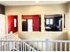 Hallway view showcasing the vibrant kitchen and a glimpse of other rooms, with white railings at 9535 Leaping Lizard St, Las Vegas, NV 89178