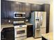 Modern kitchen with stainless steel appliances, granite countertops, and dark wood cabinets at 9535 Leaping Lizard St, Las Vegas, NV 89178