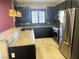 Bright kitchen boasts stainless appliances, dark cabinets, and stone backsplash at 9535 Leaping Lizard St, Las Vegas, NV 89178