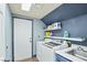 Well-equipped laundry room with storage shelves, utility sink, and modern washer/dryer at 9709 Terrace Green Ave, Las Vegas, NV 89117