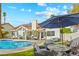 Stunning backyard with a sparkling pool, outdoor kitchen, and plenty of seating for entertaining guests at 9709 Terrace Green Ave, Las Vegas, NV 89117
