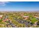 Aerial view showcases the community with lush greenery, pools, and city skyline backdrop at 10290 Profeta Ct, Las Vegas, NV 89135