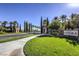 Inviting community entrance with lush landscaping, palm trees, and decorative entry gates at 10290 Profeta Ct, Las Vegas, NV 89135