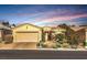 Charming single-story home showcasing a well-manicured front yard and a two-car garage under a colorful sky at 10290 Profeta Ct, Las Vegas, NV 89135