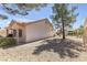 Home exterior featuring desert landscaping and gravel; tall tree gives shade to the home at 10920 Black Ledge Ave, Las Vegas, NV 89134
