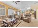 Comfortable living room featuring neutral carpeting, plantation shutters, and views into the kitchen at 10920 Black Ledge Ave, Las Vegas, NV 89134