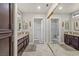 Bathroom boasts double sinks, granite countertops, dark wood cabinets, and a large framed mirror on mirrored closet doors at 10921 Grand Haven Ave, Las Vegas, NV 89134