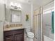 Bathroom with granite vanity, a framed mirror, and a shower-tub combination with a patterned shower curtain at 10921 Grand Haven Ave, Las Vegas, NV 89134