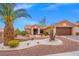 Charming landscaped front yard with crushed rock, palm trees, bushes, and a terracotta tiled roof home at 10921 Grand Haven Ave, Las Vegas, NV 89134