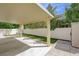 Backyard featuring a covered patio, white fence, artificial grass, and a storage shed at 1131 Sax Fifth Ave, Henderson, NV 89052
