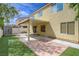 This backyard features artificial grass, a covered patio, and sliding glass doors at 1131 Sax Fifth Ave, Henderson, NV 89052