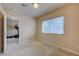 Bright bedroom featuring carpet flooring, a window with blinds, and a view to an exercise area at 1131 Sax Fifth Ave, Henderson, NV 89052