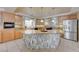Open kitchen with granite countertops, stainless steel refrigerator, tile backsplash and flooring, and breakfast island at 1131 Sax Fifth Ave, Henderson, NV 89052