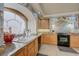 Charming kitchen featuring a double basin sink beneath an arched window and black appliances at 1131 Sax Fifth Ave, Henderson, NV 89052