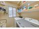 Functional laundry room with a side-by-side washer and dryer, shelving, and a window at 1131 Sax Fifth Ave, Henderson, NV 89052