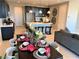 Elegant dining area with a long table set for a meal, adjacent to a modern kitchen and comfortable living space at 116 Antler Square Ln, Henderson, NV 89011