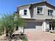 Charming two-story home with a two-car garage, brick driveway, and desert landscaping in a sunny setting at 116 Antler Square Ln, Henderson, NV 89011