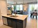 Stylish kitchen island with seating and a sink overlooking a large open-concept living and dining area at 116 Antler Square Ln, Henderson, NV 89011