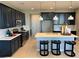 Modern kitchen with dark cabinets, stainless steel appliances, a central island, and bar stool seating at 116 Antler Square Ln, Henderson, NV 89011