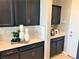A detailed view of the kitchen with black cabinets, quartz countertops and stylish geometric backsplash at 116 Antler Square Ln, Henderson, NV 89011