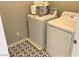 Laundry room showcasing white washer and dryer with striking starburst patterned floors at 116 Antler Square Ln, Henderson, NV 89011