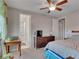 Neutral toned bedroom featuring ceiling fan, dresser, and view into Primary bath at 12249 Catanzaro Ave, Las Vegas, NV 89138