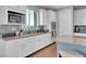 Modern white kitchen with granite countertops, stainless steel appliances, and wood floors at 12249 Catanzaro Ave, Las Vegas, NV 89138