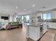 Open-concept living room with hardwood floors, island, stainless appliances, and sliding doors leading to the backyard at 12249 Catanzaro Ave, Las Vegas, NV 89138