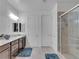 Main bathroom with double vanity, walk-in shower, and tile floor at 12249 Catanzaro Ave, Las Vegas, NV 89138