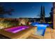 Inviting pool and spa featuring vibrant lighting and lush landscaping for evening relaxation at 12249 Catanzaro Ave, Las Vegas, NV 89138