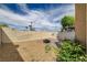 Enclosed backyard featuring privacy walls, brick patio, and a charming desert landscape at 1660 Cloister Ave, Henderson, NV 89014