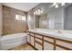 Bathroom with double sinks, vanity, and tile surround bathtub at 1660 Cloister Ave, Henderson, NV 89014