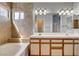 Bright bathroom featuring double sinks, decorative lighting, and tiled shower area at 1660 Cloister Ave, Henderson, NV 89014