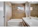 Cozy bathroom featuring a vanity with dual sinks, a window, and a bathtub at 1660 Cloister Ave, Henderson, NV 89014
