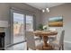 Cozy dining room showcasing a round wooden table, modern chandelier, and sliding door to patio at 1660 Cloister Ave, Henderson, NV 89014