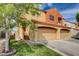 Inviting two-story home with a two-car garage, colorful exterior, and lush lawn with mature tree at 1660 Cloister Ave, Henderson, NV 89014