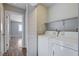 Well-equipped laundry room including washer, dryer, shelving and doorway at 1660 Cloister Ave, Henderson, NV 89014