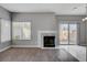 Open living room with a fireplace, sliding glass doors, and wood flooring at 1660 Cloister Ave, Henderson, NV 89014
