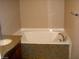 This bathroom features a white tub with a granite surround and a cultured marble sink with granite countertop at 1858 N Decatur Blvd # 204, Las Vegas, NV 89108