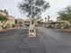 View of the entrance to a condominium complex, featuring a security gate, mature landscaping, and well-maintained grounds at 1858 N Decatur Blvd # 204, Las Vegas, NV 89108