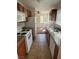 Functional kitchen featuring white appliances, wood cabinets, granite counters, and tile flooring at 1858 N Decatur Blvd # 204, Las Vegas, NV 89108
