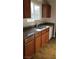 This kitchen features a stainless steel sink, granite countertops, wood cabinets, and a white dishwasher at 1858 N Decatur Blvd # 204, Las Vegas, NV 89108